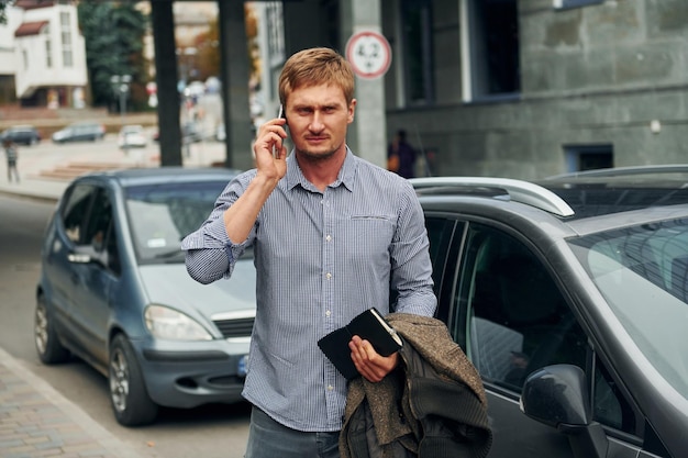 Talking by phone Man having a walk outdoors in the city at daytime