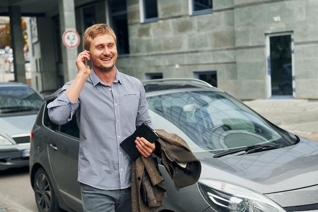 Talking by phone Man having a walk outdoors in the city at daytime