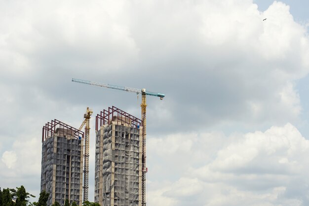 Tall building under construction and have a crane in the construction site