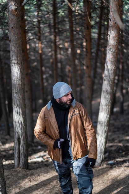 tall guy with a beard on the mountain wearing warm clothes and posing