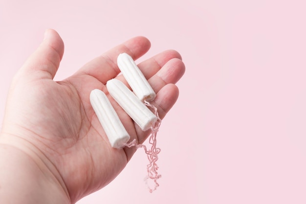 Tampons in female hands Lack of feminine hygiene products