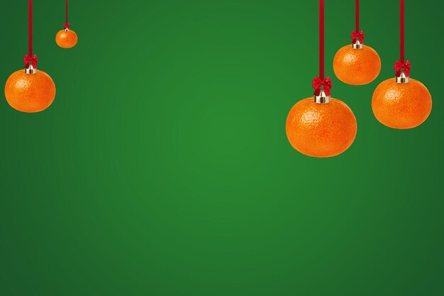 Tangerine as a Christmas ornament on green background with copy space Creative Christmas greeting card