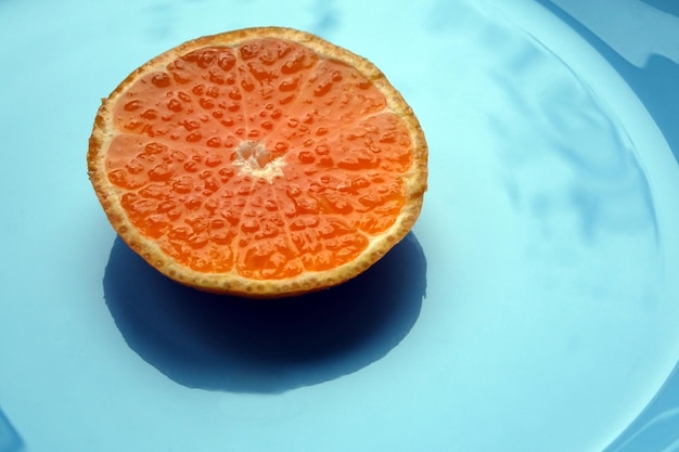 Tangerine slice on a blue plate Bright juicy mandarin