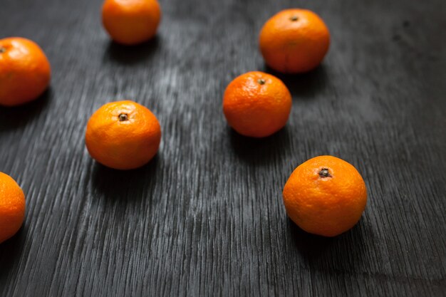 Tangerines on a black background. Lots of fresh fruit - mandarins.