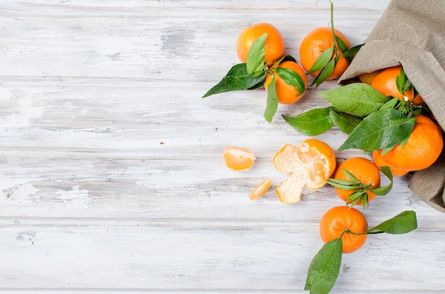 Photo tangerines clementine with leaves on a wooden table.