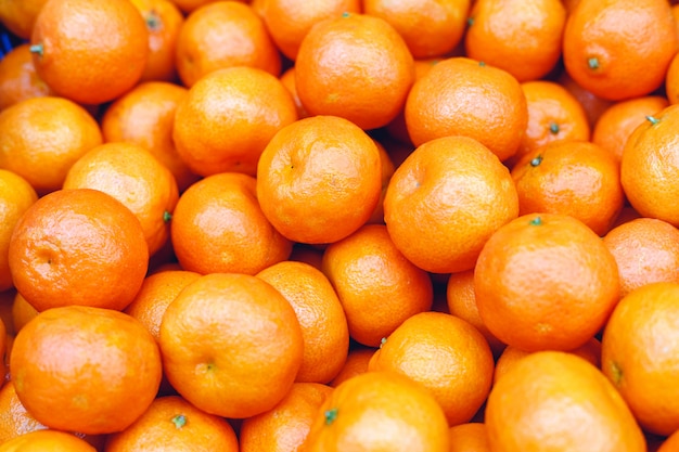 Tangerines or fresh mandarin oranges fruit as background. Organic tangerine fruit for sale at market, shop. Healthy nutrition, fruit eating concept.