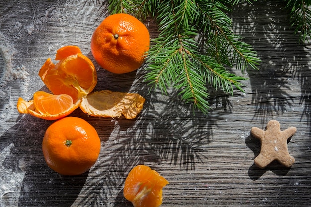 Tangerines gingerbread and cookies on a wooden table sprinkled with white flour in the form of snow