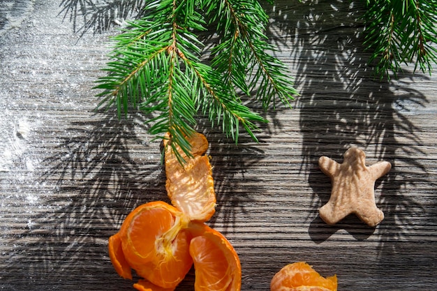 Tangerines gingerbread and cookies on a wooden table sprinkled with white flour in the form of snow