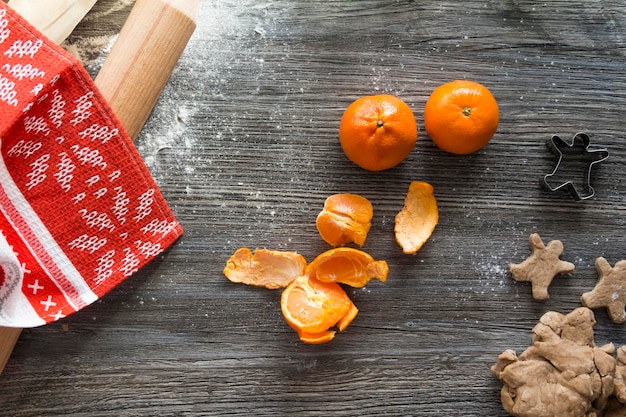 Tangerines gingerbread and cookies on a wooden table sprinkled with white flour in the form of snow