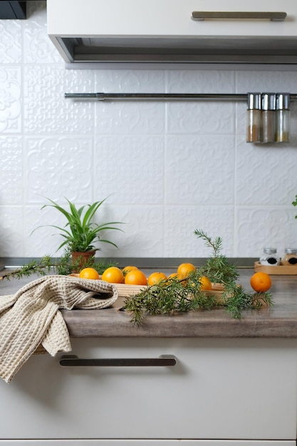 Tangerines on a wooden plate in a white kitchen. New Year's mood, the holiday is coming