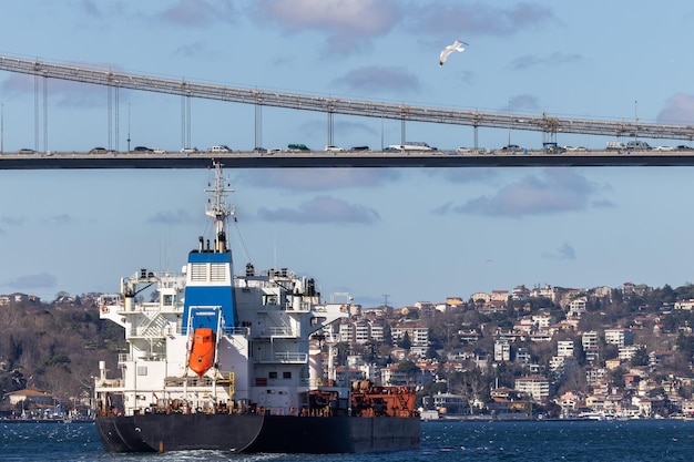 Tanker ship pass through the Bosporus with Bosphorus Bridge in Istanbul Turkey or Turkiye Bosphorus strait connecting Europe to Asia Tanker ship in Istanbul Turkey