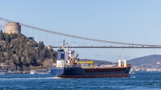 Tanker ship pass through the Bosporus with Bosphorus Bridge in Istanbul Turkey or Turkiye Bosphorus strait connecting Europe to Asia Tanker ship in Istanbul Turkey