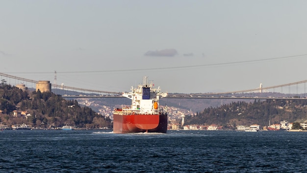 Tanker ship pass through the Bosporus with Bosphorus Bridge in Istanbul Turkey or Turkiye Bosphorus strait connecting Europe to Asia Tanker ship in Istanbul Turkey