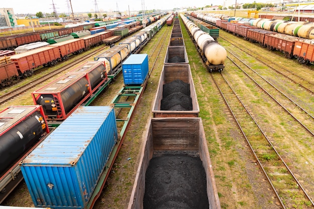 Tanks with fuel, wagons with cargo at a freight railway station. Logistics and transportation concept.