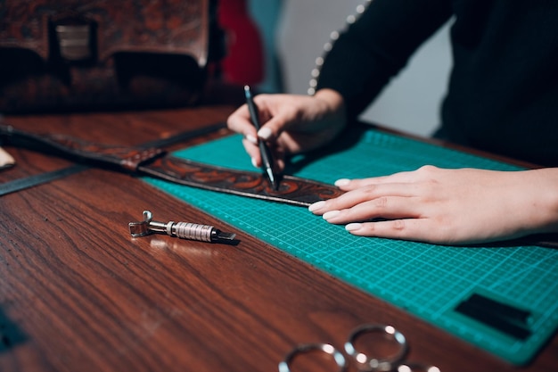 Tanner woman making leather goods on workshop Working process of leather craftsman