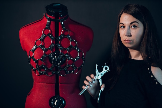 Tanner woman portrait with leather harness on mannequin