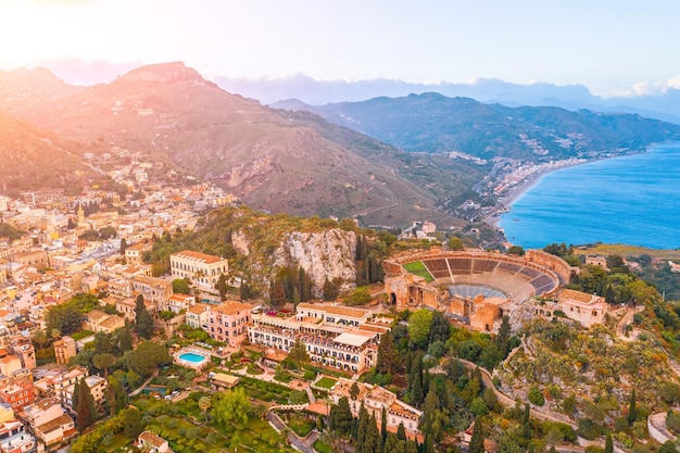 Taormina theater amphitheater arena is a town on the island of Sicily Italy Aerial view from above in the evening sunset