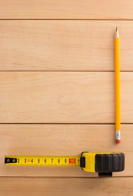 Tape measure and pencil on wood