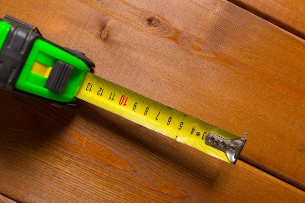 Tape measure on wooden background. top view.