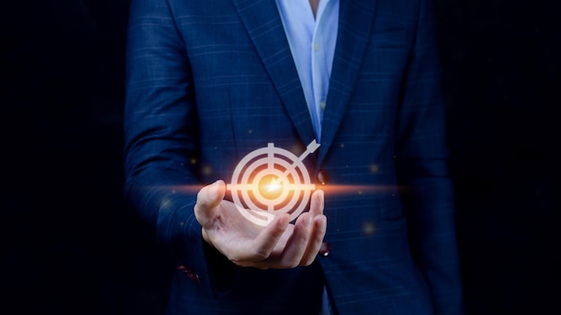 Targeting concept with businessman hand holding digital image of dartboardBusinessman holding virtual dartboard and arrow with copy space for setup business objective target concept