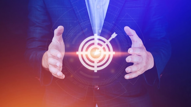 Targeting concept with businessman hand holding digital image of dartboardBusinessman holding virtual dartboard and arrow with copy space for setup business objective target concept