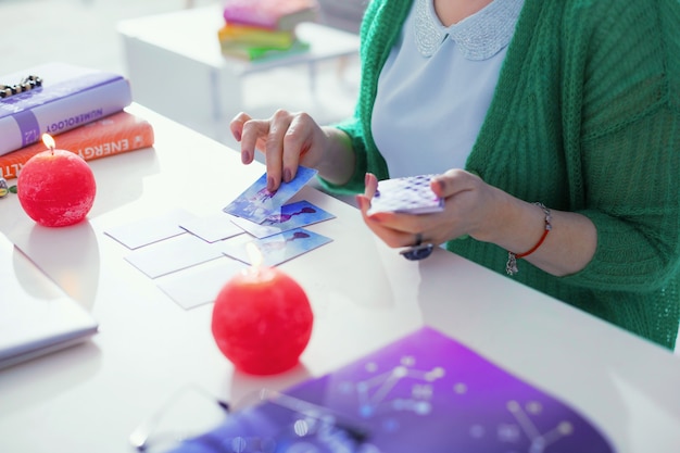 Tarot cards in fortune-telling. Top view of tarot cards being put on the table while a professional fortune teller