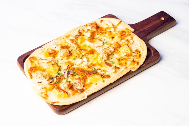 Tart flambe seafood pizza on wood board