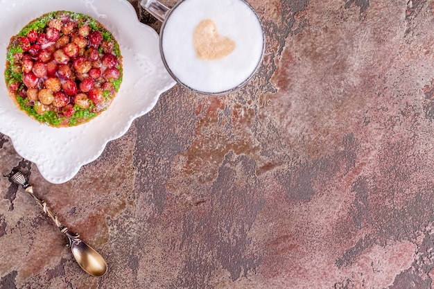 Tart on white plate with vintage spoon and cup of coffee