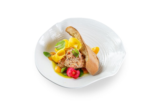 Tartar with pasta egg yolk and croutons on a white isolated background