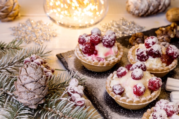 Tartlets with cottage cheese and raspberries on a bright table.