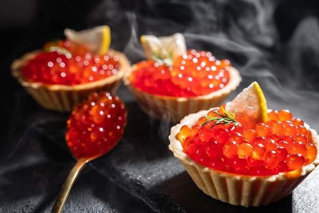 Tartlets with red caviar close-up