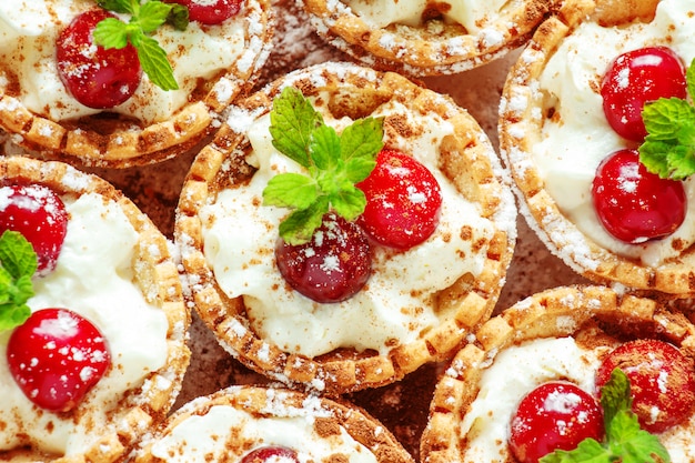 Tartlets with whipped cream and cherry.