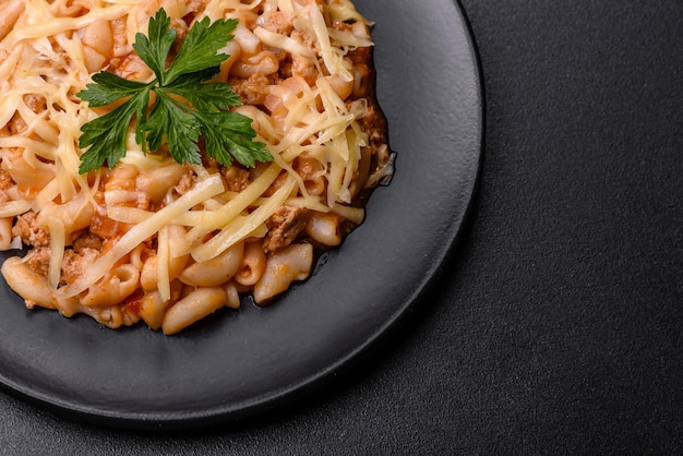 Tasty appetizing classic italian pasta with tomato sauce and cheese on plate on dark background