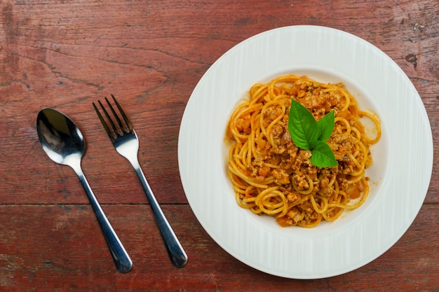 Tasty appetizing classic Italian spaghetti pasta with tomato sauce and basil on plate