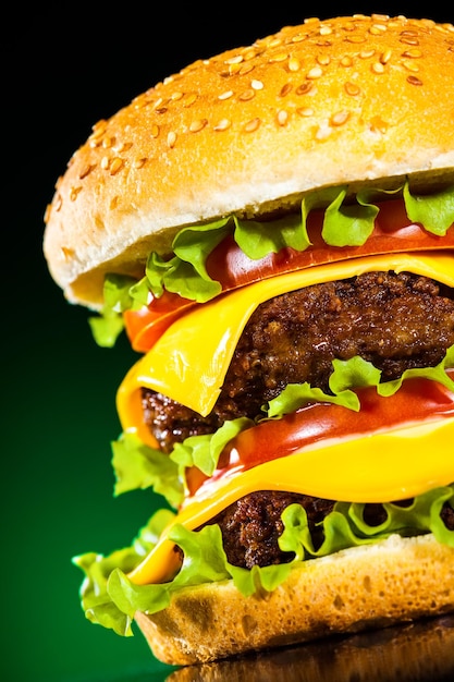 Tasty and appetizing hamburger on a darkly green background