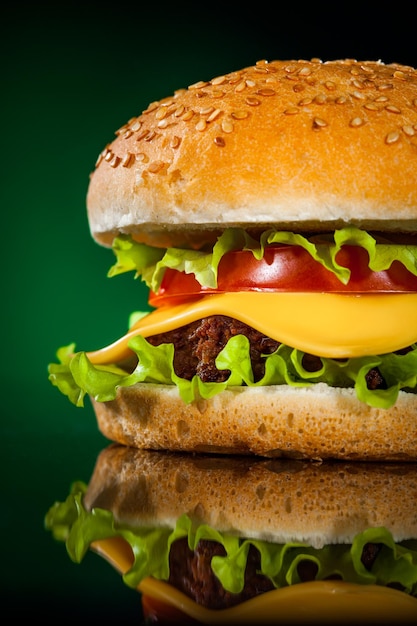 Tasty and appetizing hamburger on a darkly green background