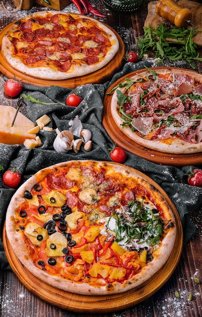 Tasty assorted three pizzas on a wooden background