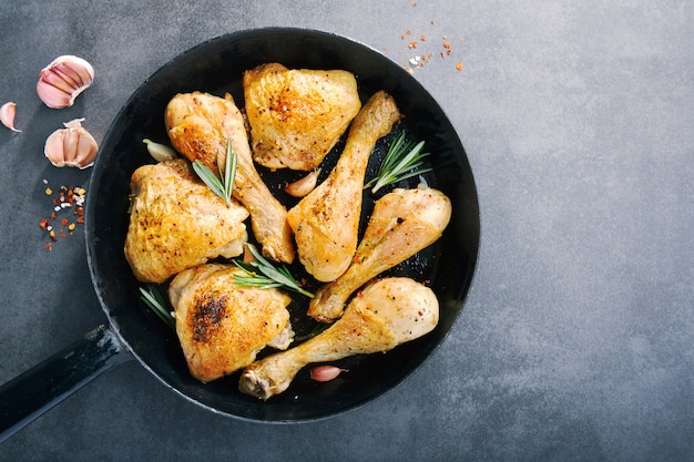 Photo tasty baked chicken legs with spices on pan