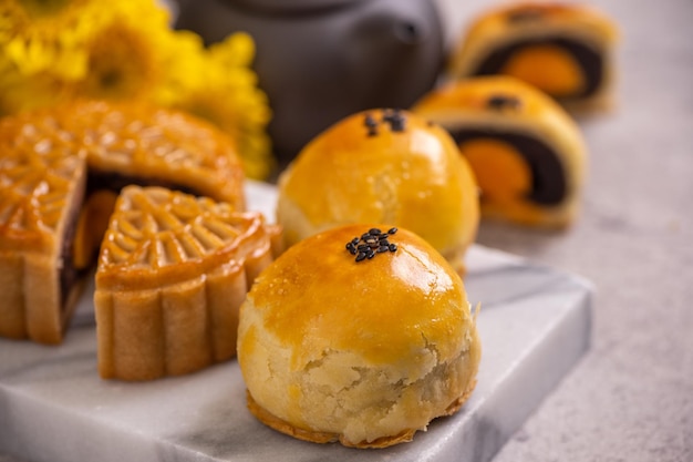 Tasty baked egg yolk pastry moon cake for MidAutumn Festival on bright cement table background Chinese traditional food concept close up copy space