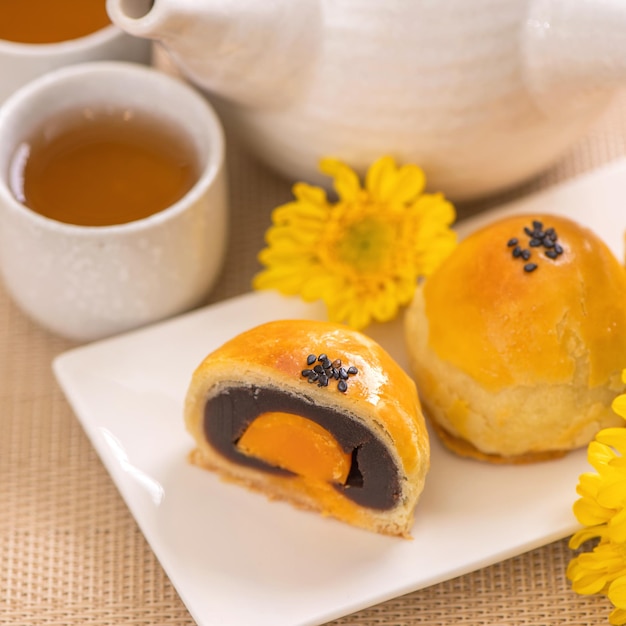 Tasty baked egg yolk pastry moon cake for MidAutumn Festival on bright wooden table background Chinese festive food concept close up copy space