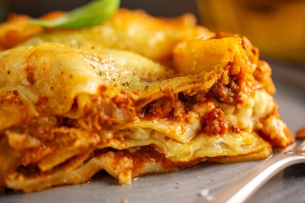 Tasty baked prepared classic italian lasagne in casserole on bright background. Closeup