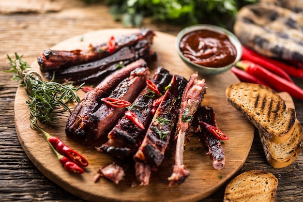 Tasty barbecue grilled pork ribs with chili pepers and parsley herbs.