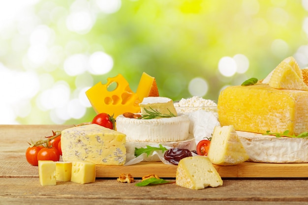 Tasty beautiful cheese composition on wooden board