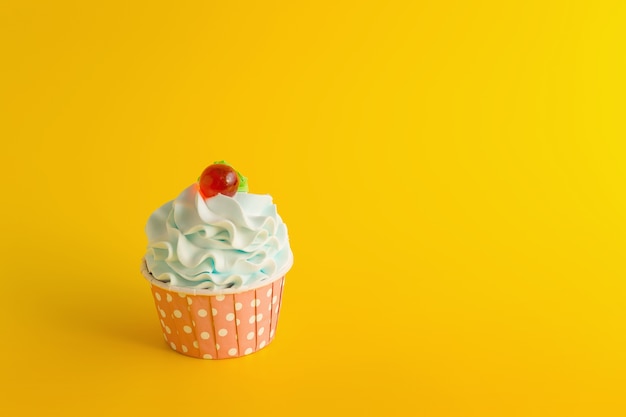 Tasty Birthday cupcake on yellow color background.