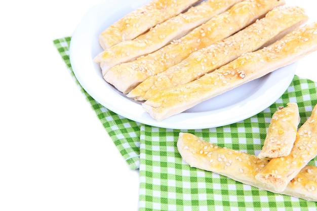 Tasty bread sticks on plate isolated on white