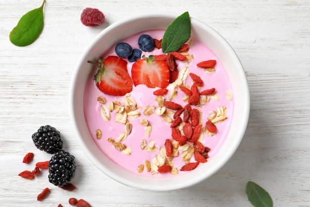 Tasty breakfast with goji berries in bowl on table