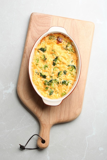 Tasty broccoli casserole on grey marble table top view