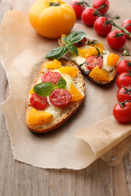 Tasty bruschetta with tomatoes on old wooden table