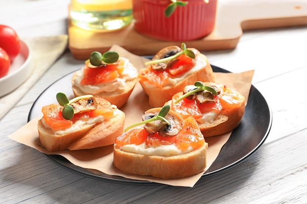 Tasty bruschettas with salmon on plate closeup