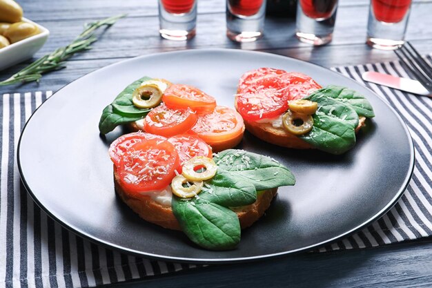 Tasty bruschettas with tomatoes and olives on plate